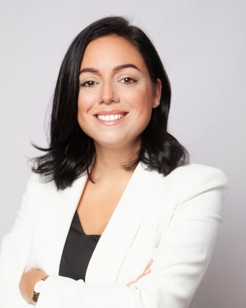 Retrato de Patricia Barrios, sonriendo, con blazer blanco
